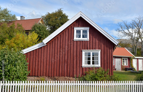 front view of a typical red sweden house with white fence