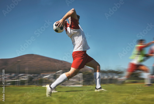 Training, man and soccer ball throw on soccer field during game or competition outdoor. Sports, fitness and football player pitching ball during practice, exercise or workout session on grass field