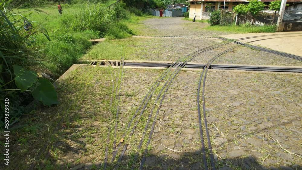 Aerial view following an old railway rails in sunny Roca Agostinho Neto, Sao Tome - low, drone shot