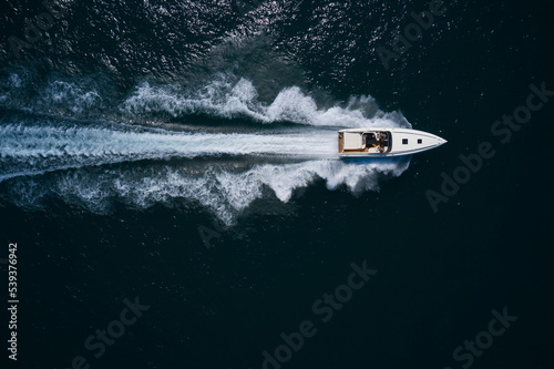 boat performance fast movement on dark water top view. © Berg