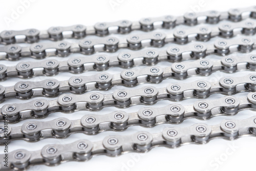 Fototapeta Naklejka Na Ścianę i Meble -  View of Shiny Dirty Greasy Oiled Bicycle Chain As A Part of Metal Bicycle Equipment On Grey Tile Stony Background With Contrast Details.Vertical Image Composition