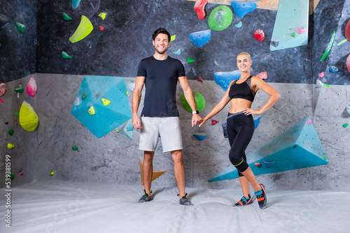 Bouldering Concepts. One Joyful couple Preparing To Bouldering climbing up the wall together.
