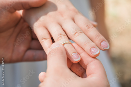 A man puts a wedding ring on a woman's finger, Close-up.