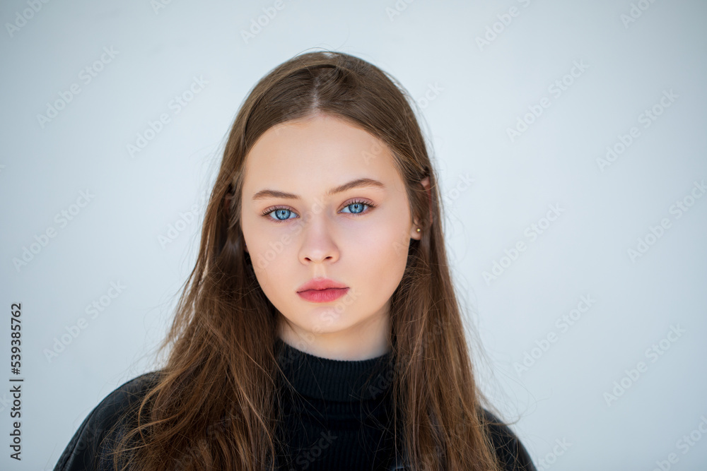 Portrait of a beautiful young teen girl with blue eyes on a light background. natural beauty white skin.   