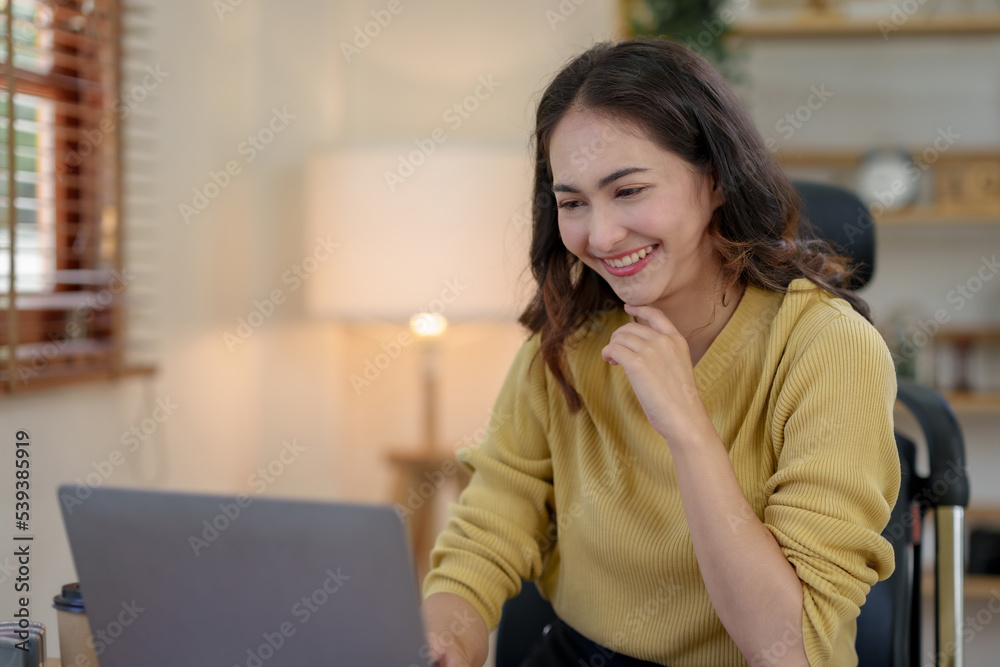 Bright, cute and happy Asian female student study online in the living room using laptop computer in a relaxed manner. Young Asian woman using laptop at home. Bright, cute and happy Asian female student study online in the living room using laptop computer in a relaxed manner. Young Asian woman using laptop at home.