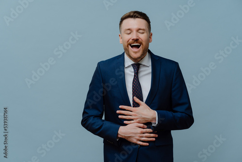 Overjoyed businessman in suit laughing out loud and having fun