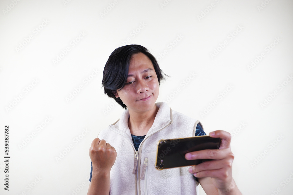 Asian man addicted to play mobile game. Asian man addicted to play mobile game.