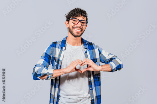 Teenage guy making heart shape with hands isolated. Happy man making heart shape with hands isolated. Person putting hands together in a heart shape
