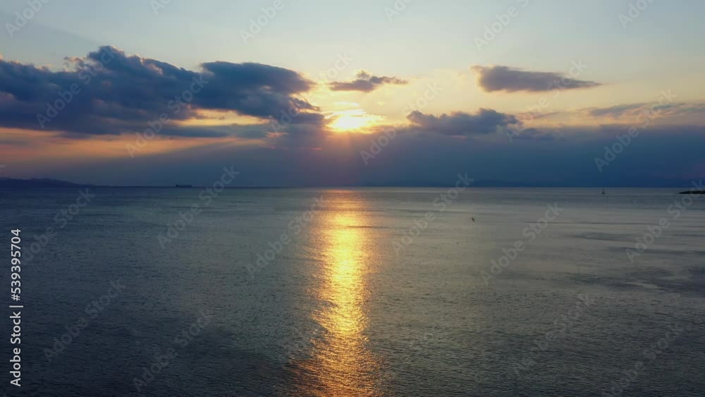 Aerial - Sunset behind clouds in Vouliagmeni, Greece Aerial - Sunset behind clouds in Vouliagmeni, Greece