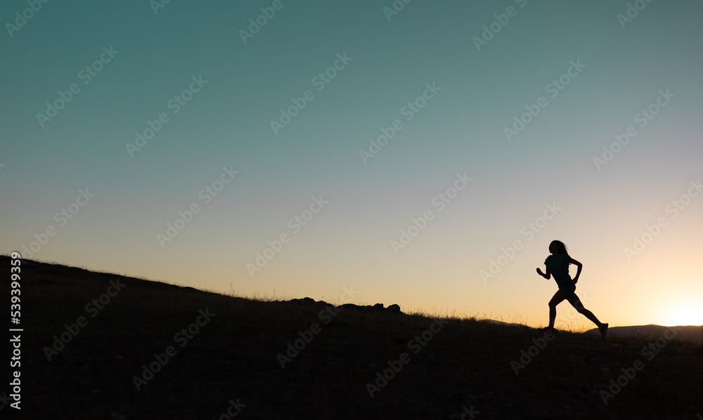 girl runs at sunset in the mountains.
