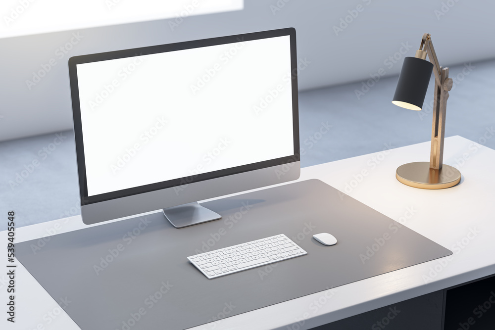 Fototapeta premium Close up of office desk top with empty white computer monitor and mock up place for your advertisement, lamp and keyboard on blurry background. 3D Rendering.