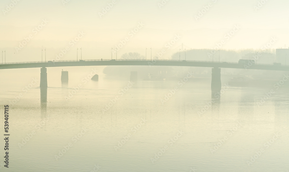 Petrovaradin bridge in the autumn period of the year. A view of the Petrovaradin bridge and the Danube river, covered with autumn fog.