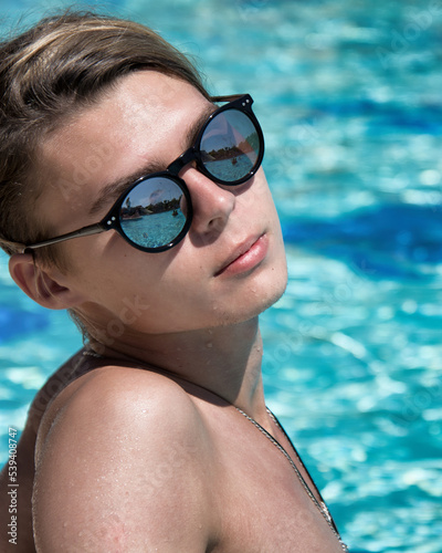 Early morning. Vacation and holidays. A young attractive guy is relaxing in the pool. © vladorlov