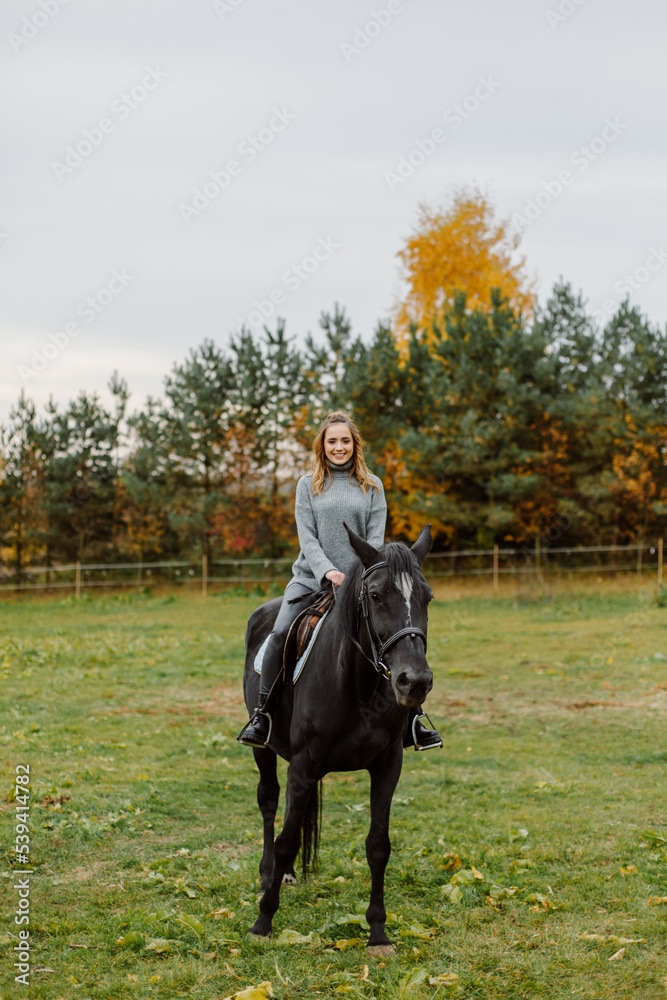 Woman on a horse at rancho. Horse riding, hobby time. Concept of animals and human Woman on a horse at rancho. Horse riding, hobby time. Concept of animals and human