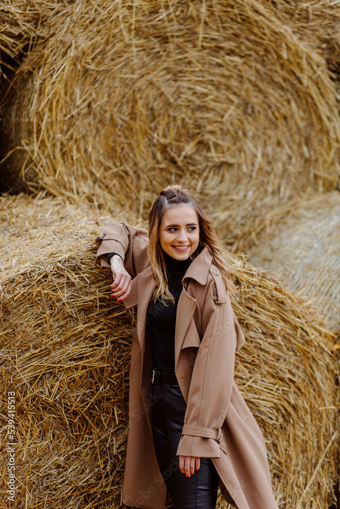 Cute smiling girl with hat posing in front of wheat straw bale Cute smiling girl with hat posing in front of wheat straw bale