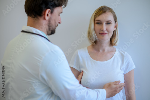 Professional mammologist examining mammary glands of a woman photo