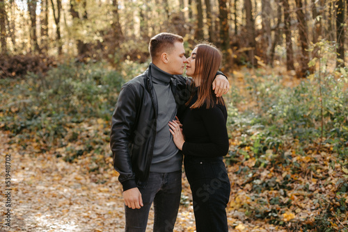 Lovely couple posing in autumn forest, lovers walking in park. lovestory in forest photo