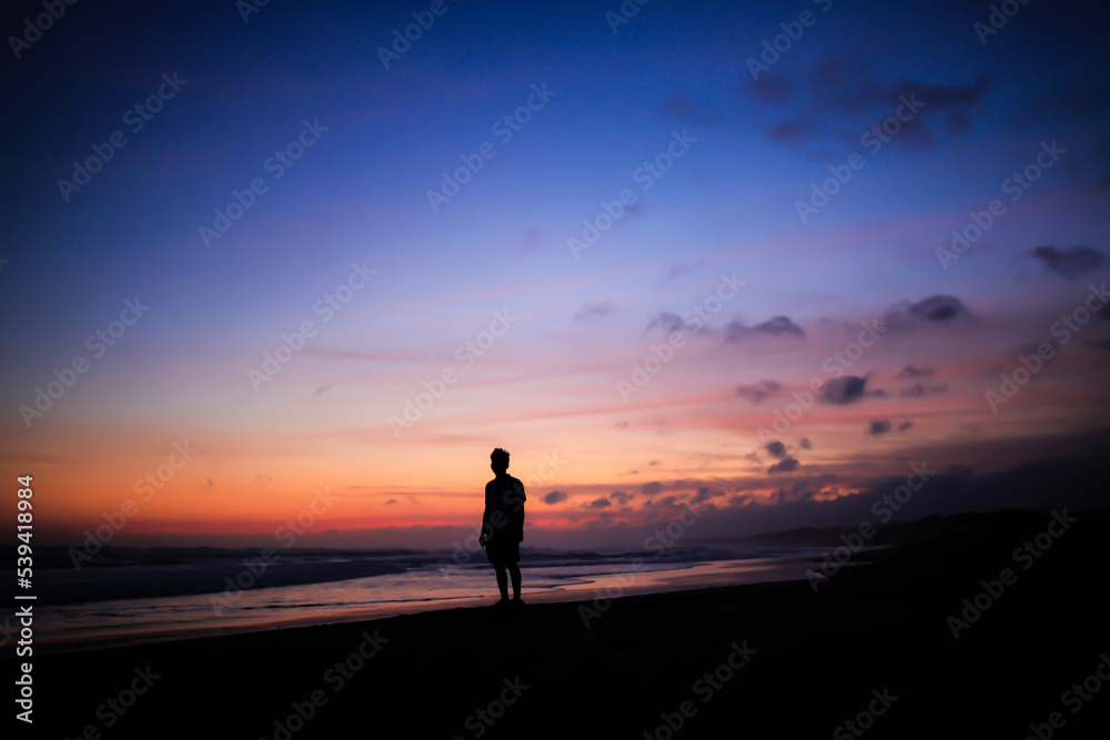 silhouette of people standing on the beach at dusk with random hair random