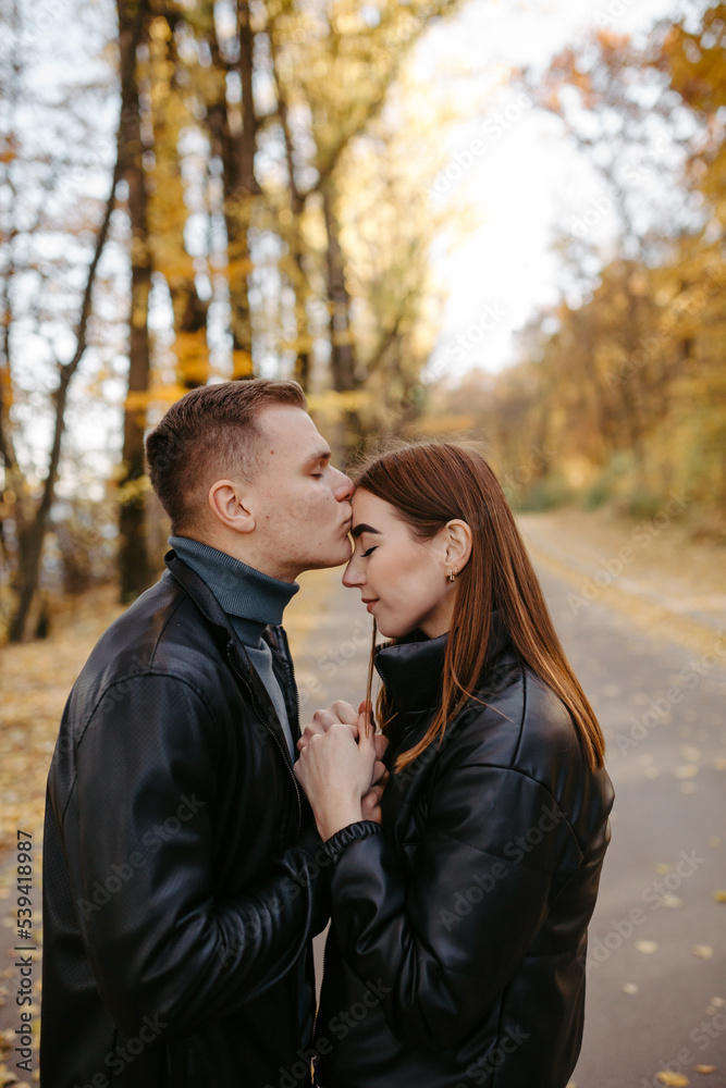 Lovely couple posing in autumn forest, lovers walking in park. lovestory in forest Lovely couple posing in autumn forest, lovers walking in park. lovestory in forest