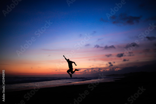 silhouette of a person jumping as if he wanted to fly © adelukmanulhakim