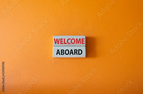 Welcome aboard symbol. Concept word Welcome aboard on wooden blocks. Beautiful orange background. Business and Welcome aboard concept. Copy space