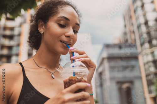 Cute young girl in sportsear having her morning coffee outside