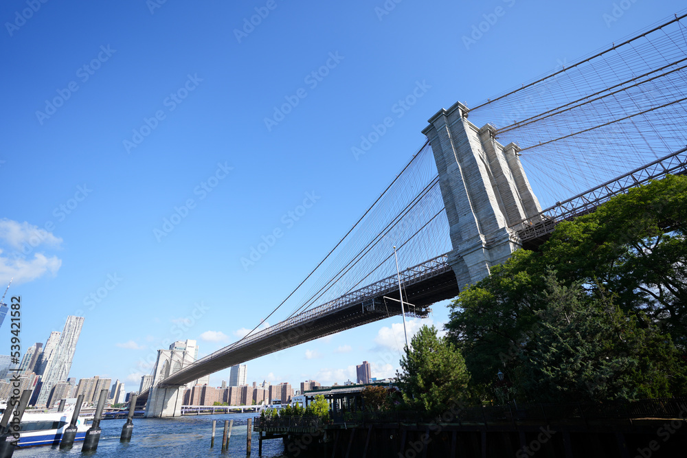 Obraz premium New York City, New York USA - September 2022. Manhattan bridge. Iron bridge view. Historic New York place. Brick wall buildings. Brownstone building.