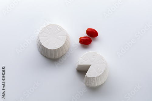whole ricotta with fresh tomato on a white background