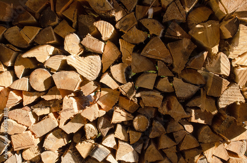 Chopped and stacked firewood lies in a pile for burning  wooden background.