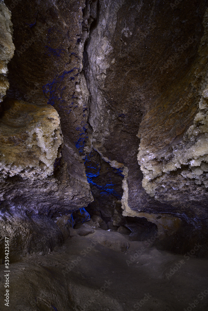 A view in a cave with gypsum crystals on the walls, which shine like small stars from the light of lanterns. A view in a cave with gypsum crystals on the walls, which shine like small stars from the light of lanterns.