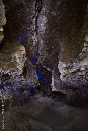 A view in a cave with gypsum crystals on the walls, which shine like small stars from the light of lanterns.