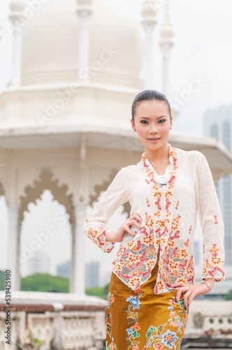 Fashion portrait photo of a beautiful elegant young asian female lady model wearing traditional baba-nyonya peranakan culture kebaya garment dress with sarong posing with different looks and gesture