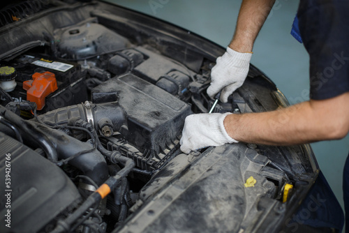 Mechanic man examining and maintenance to customer the engine a vehicle car hood