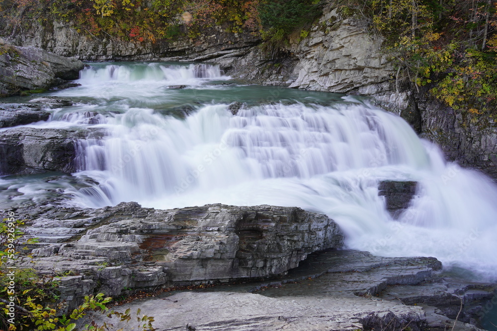 Obraz premium 紅葉している葉っぱとダイナミックな芦別の三段の滝