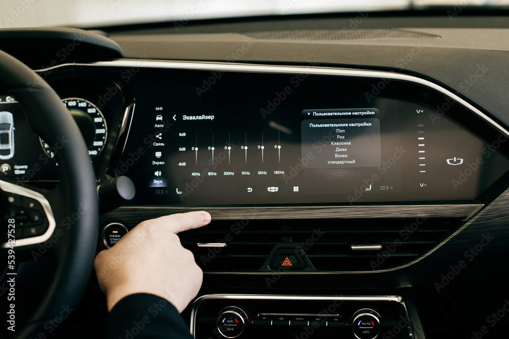 Car dashboard. Radio closeup. Man sets up radio Car dashboard. Radio closeup. Man sets up radio