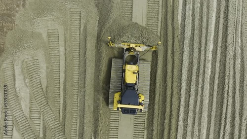 Top view of large bulldozer or crawler with GPS moving sand at construction site.