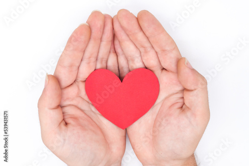 hands holding a paper heart on a white background as a concept of cardiovascular health, heart problems, heart attacks, love, feelings,