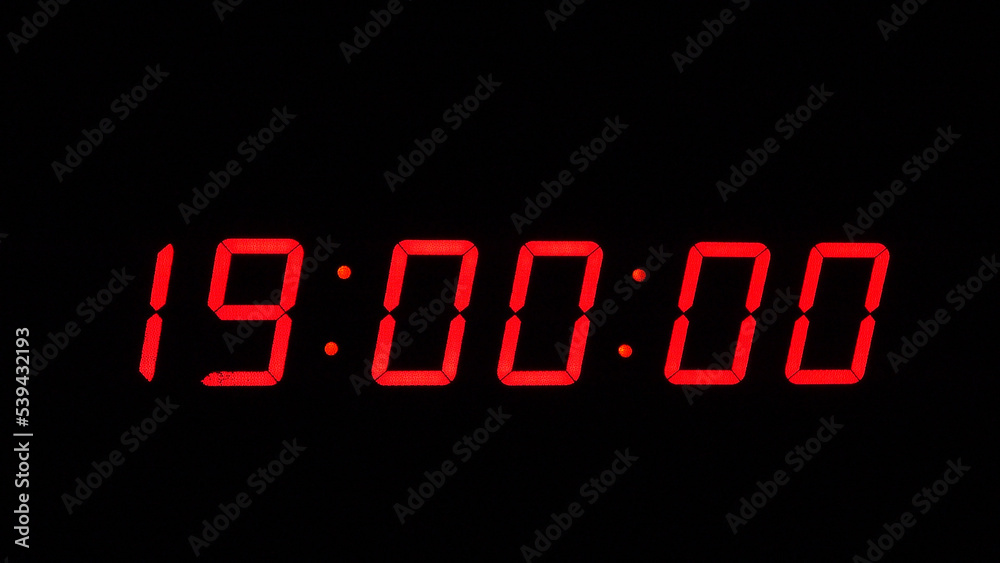 Digital timer on a black background. Light panel with red numbers. 19 o'clock