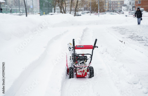 Russia Moscow 13.02.2021 Street snow blower. Self cleaning snow from road, sidewalk. Tractor, snow removal equipment. City winter weather collapse, snowfall, snowdrifts. Heavy snowstorm, blizzard