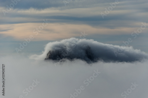 tip of the island of Es Vedra in Ibiza rising out of the mist in winter