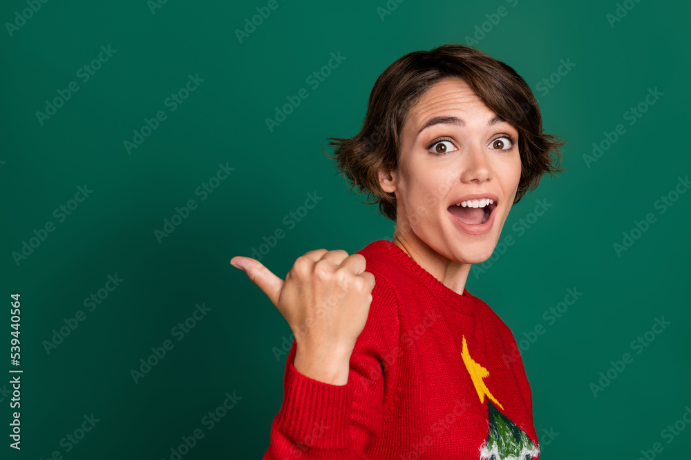 Close up photo of astonished lady arm thumb direct empty space recommend buy stylish clothes low price isolated on green color background Close up photo of astonished lady arm thumb direct empty space recommend buy stylish clothes low price isolated on green color background
