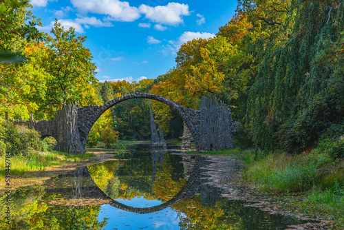 Fototapeta Naklejka Na Ścianę i Meble -  Arch Bridge in Kromlau, Saxony, Germany. Colorful autumn in Germany. Rakotz bridge in Kromlau