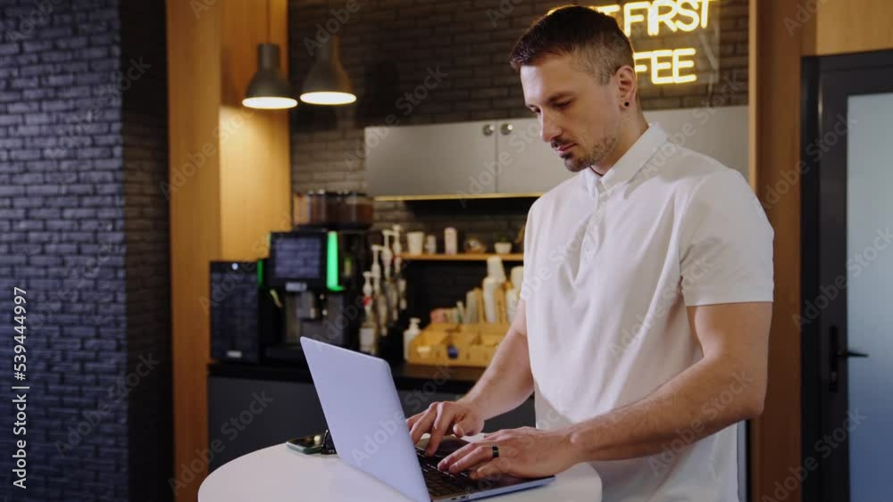 A man is working at a laptop in the office A man is working at a laptop in the office