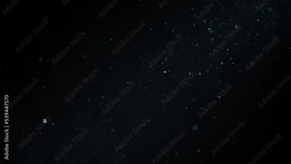 Background of white dust particles flowing in the dark. Slow motion. Background of white dust particles flowing in the dark. Slow motion.
