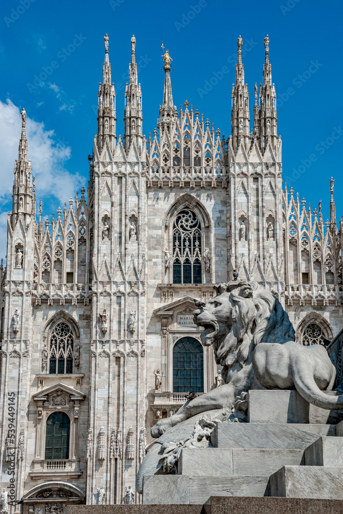 View of magnificent Cathedral of Milano, Duomo di Milano and big lion statue, Milan, Italy