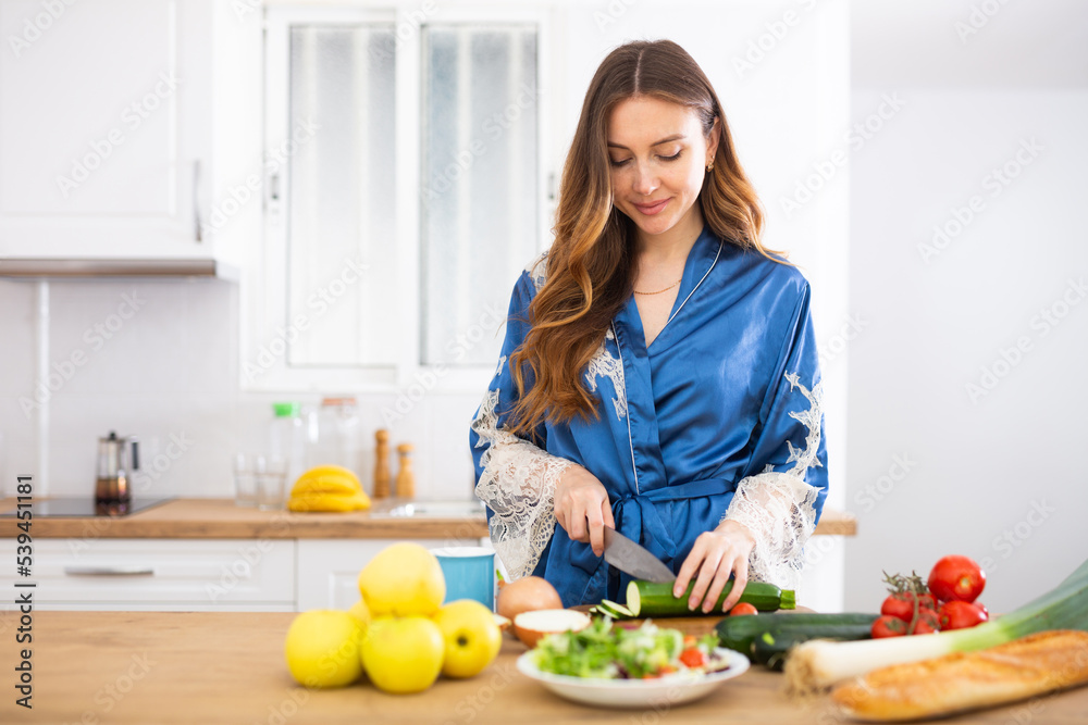 Smiling woman cooking dinner at home