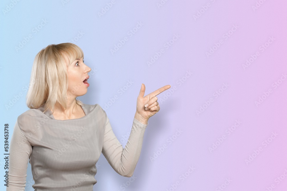 Beautiful young woman pointing to side with finger Beautiful young woman pointing to side with finger