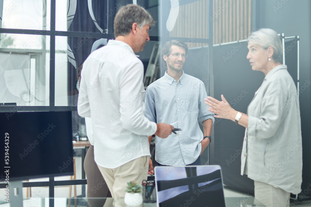 manager discussing business documents with a group of employees.