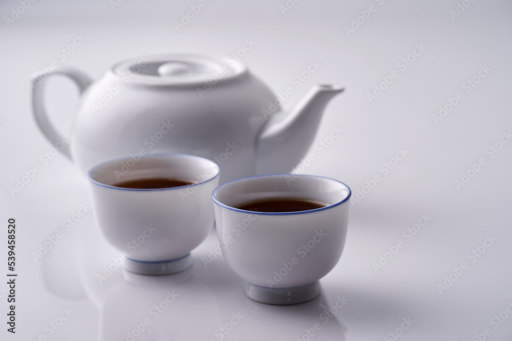 two tea cups and teapot against with background with reflection two tea cups and teapot against with background with reflection