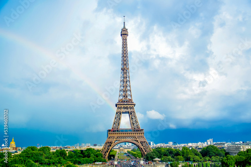 Eiffel Tower in Paris against the blue sky and rainbow. Landscape of a beautiful European city in France, tourism and travel in a romantic place.